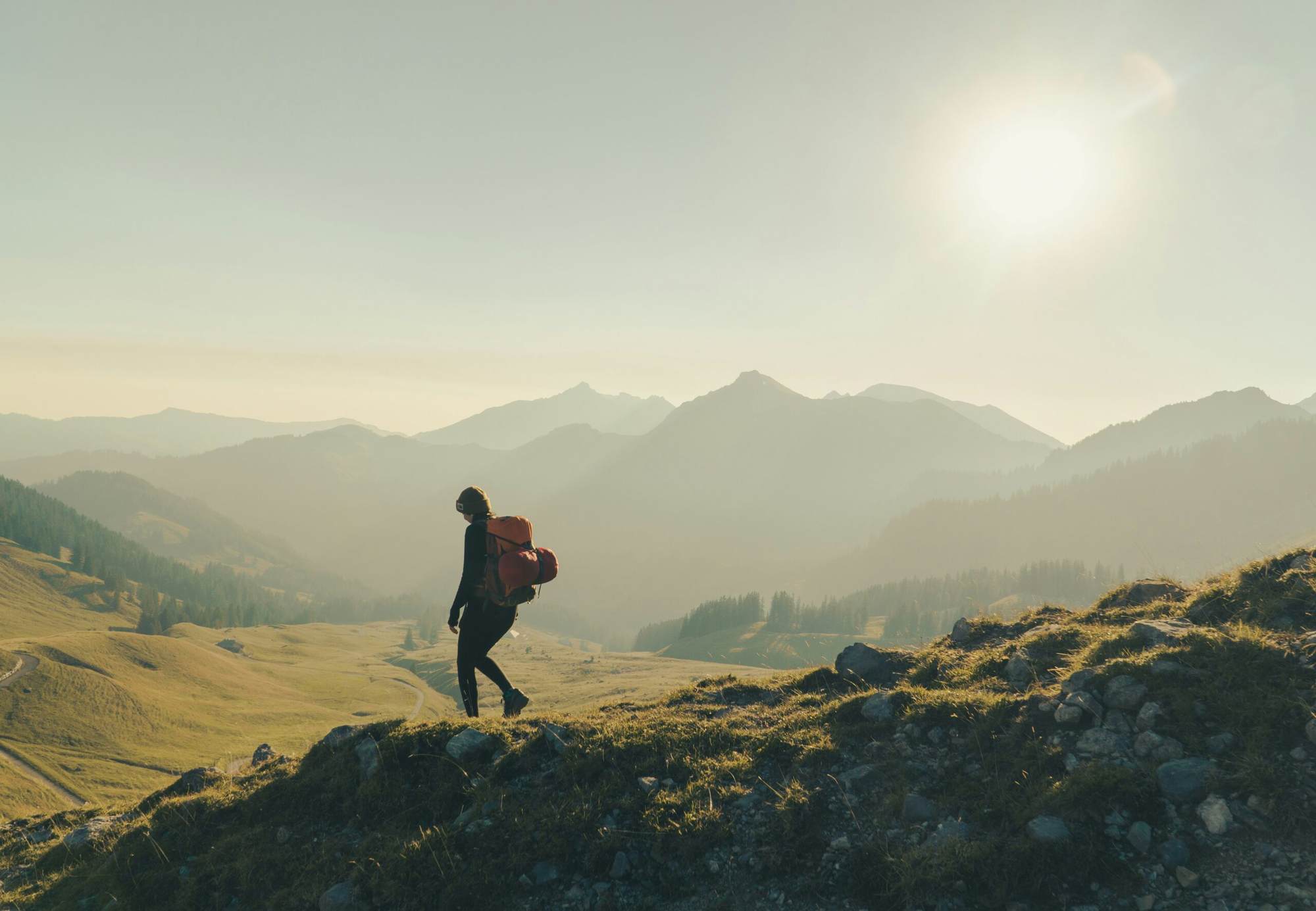 Wandelaar met rugzak in een berglandschap tijdens een lichte trektocht